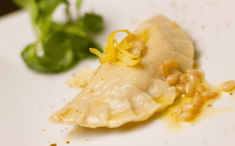 Ravioli di merluzzo bianco e pancetta affumicata, vellutata di crescione al limone candito